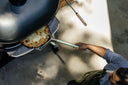 Overhead view of a cook removing cheese pizza from an Off Black Gozney Dome XL Gen 2 with a placement peel.