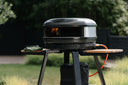 Off Black Gozney Arc XL on a Gozney Arc Stand with side shelves in a garden
