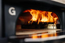Gozney Dome and Dome XL Wood-Fire Control Kit wood rack in use inside a Dome Gen 2, with burning wood and flames