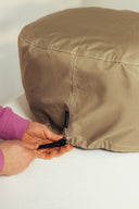 Hands tightening the drawcord on the beige Gozney Arc Lite Cover