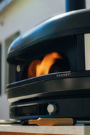 Close-up of an Off Black Gozney Dome Gen 2 with flames inside its open mouth.